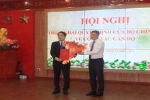 Đồng chí Lê Minh Hưng, Ủy viên Bộ Chính trị, Bí thư Trung ương Đảng, Trưởng Ban Tổ chức Trung ương trao quyết định, tặng hoa đồng chí Nghiêm Xuân Thành. (Ảnh: PHONG NGUYÊN)