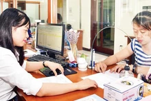 Giải quyết thủ tục hành chính cho người dân tại bộ phận một cửa UBND quận Hai Bà Trưng. (Ảnh minh họa: THÀNH NGUYỄN)