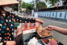 Những quán hàng rong với nhiều loại thức ăn, nước uống được bày bán tại khu vực cổng trường học không bảo đảm vệ sinh an toàn thực phẩm. (Ảnh ĐỖ VI)