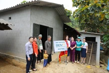 Đại diện chính quyền địa phương cùng doanh nghiệp tài trợ trao nhà mới cho gia đình ông Giàng Vảng Dinh. (Ảnh: NHẬT QUANG)