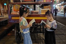 Đường sách phố cổ thu hút cả các bạn đọc nhí ở Hội An. (Ảnh QUỐC BẢO)
