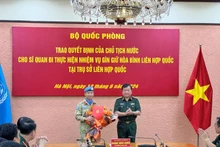 Thượng tướng Hoàng Xuân Chiến trao Quyết định của Chủ tịch nước và tặng hoa chúc mừng Thượng tá Trương Anh Tuấn đi thực hiện nhiệm vụ tại Trụ sở Liên hợp quốc.