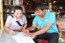 Trưởng bon Sa Nar, xã Quảng Sơn, huyện Đắk Glong (Đắk Nông) K'Thăn đến từng hộ gia đình lấy ý kiến cử tri về sắp xếp đơn vị hành chính các cấp.