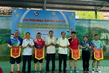 Ban tổ chức trao cờ lưu niệm cho các đội tham dự giải.
