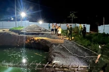 Lực lượng chức năng và người dân tìm kiếm tại khu vực hố sụt trong đêm 26/7. (Ảnh: TUẤN SƠN).