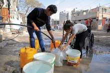 Người dân ở phía nam Dải Gaza lấy nước phục vụ sinh hoạt. (Ảnh TÂN HOA XÃ) 