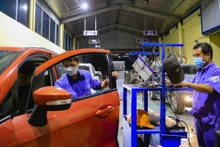 Nhân viên Trung tâm đăng kiểm 2927D (đường Phạm Văn Ðồng, Hà Nội) kiểm định phương tiện. 