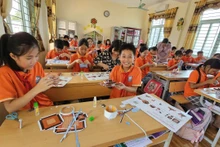Học sinh Trường tiểu học Đại Đồng, huyện Vĩnh Tường phấn khích với mô hình Cột cờ Hà Nội của Báo Nhân Dân tặng. 