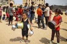 Trẻ em mất nhà cửa ở Gaza chờ nhận hàng cứu trợ. 