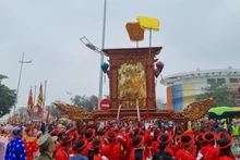 Người dân rước kiệu thánh ra sông Hồng làm lễ rước nước tại Lễ hội Đình Nhật Tân. (Ảnh: DIỆP VÂN)