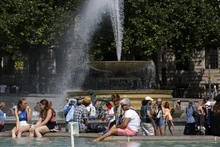 Người dân tránh nóng bên đài phun nước tại Quảng trường Trafalgar ở thủ đô London, Anh, ngày 17/6/2022. (Ảnh: AFP/TTXVN)