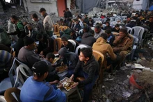 Người dân Palestine ngồi ăn giữa những ngôi nhà bị phá hủy tại thị trấn Jabalia, phía bắc Dải Gaza.