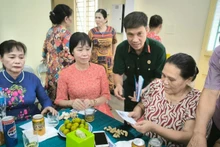 Cựu chiến binh Hoàng Văn Đạt (áo bộ đội) tặng quà các gia đình chính sách phường Đức Giang. 