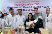 Niềm vui của gia đình chị Dung khi đón cậu con trai bé nhỏ từ tay PGS, TS Trần Danh Cường.
