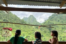 Các con của anh Sùng Văn Đình đang vui chơi bên hiên của ngôi nhà mới. (Ảnh: THI PHONG)