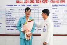 Tiến sĩ, bác sĩ Lê Đức Nhân, Giám đốc Bệnh viện Đà Nẵng tặng hoa, chúc mừng bệnh nhân, sáng 27/11. (Ảnh: ANH ĐÀO)