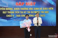 Chủ tịch UBND thành phố Lê Trung Chinh tặng Bằng khen và tiền thưởng cho học sinh Lê Ngọc Bảo Anh. (Ảnh: ANH ĐÀO)