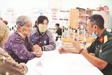 Bác sĩ quân y Phạm Văn Dũng (Cục 12) khám chữa bệnh cho người có công. (Ảnh ANH THẾ)
