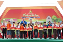 Phó Chủ tịch Hội đồng Đội Trung ương, Giám đốc Trung tâm Hỗ trợ và Phát triển thiếu nhi Việt Nam Lê Anh Quân (bên trái, hàng sau) cùng đại diện Ban tổ chức Ngày hội trao học bổng tặng thiếu nhi hoàn cảnh khó khăn.