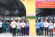 Các đồng chí lãnh đạo huyện Mường Ảng cùng các đại biểu, nhân dân huyện Mường Ảng gắn biển công trình chợ trung tâm xã Búng Lao.