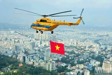 Máy bay trực thăng kéo cờ Tổ quốc luyện tập trên bầu trời Thành phố Hồ Chí Minh.