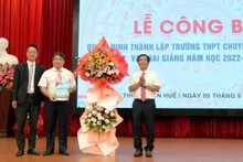 Chủ tịch UBND tỉnh Thừa Thiên Huế Nguyễn Văn Phương trao quyết định và tặng hoa chúc mừng nhà trường. (Ảnh: Trường đại học Khoa học cung cấp)