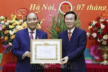 Đồng chí Võ Văn Thưởng trao tặng Huy hiệu 40 năm tuổi Đảng cho đồng chí Nguyễn Xuân Phúc. (Ảnh: Thống Nhất/TTXVN)