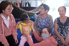 Lực lượng chức năng huyện Đầm Dơi (tỉnh Cà Mau) kiểm tra vết thương trên cơ thể cháu bé có dấu hiệu bị bạo hành.