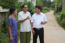 Ông Ma Hữu Khang (giữa) trao đổi về công tác vận động nhân dân hiến đất làm đường.