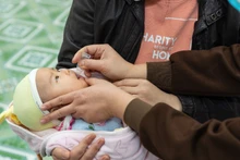 Cho trẻ uống vaccine Rota tại trung tâm y tế. 