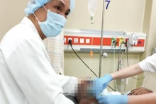 Bác sĩ Trần Minh Giang đang theo dõi nhịp tim của bệnh nhân Singapore. 