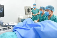 Phó Giáo sư, Tiến sĩ Lê Hoàng đang chọc hút noãn cho người bệnh.