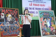 Học sinh trình bày ý nghĩa tác phẩm tại lễ trao giải Hội thi vẽ tranh cổ động về phòng, chống ma túy tại quận Cẩm Lệ (thành phố Đà Nẵng). (Ảnh ĐINH NGA) 