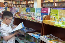 Học sinh lựa chọn sách giáo khoa tại nhà sách. (Ảnh NGUYÊN KHÔI)