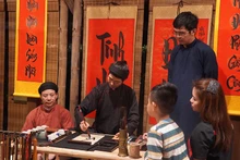 Khách du lịch xin chữ khi tham gia tour đêm tại Văn Miếu - Quốc Tử Giám.