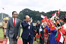 Chủ tịch nước Nguyễn Xuân Phúc và Tổng thống nước Cộng hòa Indonesia Joko Widodo tại lễ đón. (Ảnh: TTXVN)