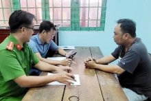 Đối tượng Đinh Thành Hiếu (bên phải) tại cơ quan Công an. 