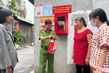 Công an phường Tân Chánh Hiệp (quận 12) hướng dẫn người dân sử dụng bình chữa cháy.