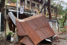 Cây xanh bị gãy đổ la liệt, mái tôn bay khắp nơi, gây ách tắc giao thông, làm hư hỏng lưới điện và thông tin liên lạc. Ảnh: QUANG DŨNG