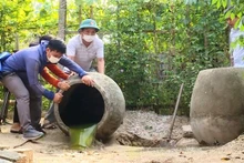 Các lực lượng chức năng trợ giúp hộ dân ở phường Hải Thanh đổ kiệt nước đọng trong các chum.