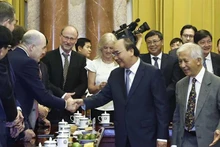 Chủ tịch nước Nguyễn Xuân Phúc và các nhà khoa học quốc tế. (Ảnh: Thống Nhất/TTXVN) 