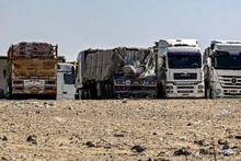 Xe tải chở hàng viện trợ cho Dải Gaza tập trung gần cửa khẩu Rafah bên phía Ai Cập, ngày 23/3. (Ảnh: AFP/TTXVN)