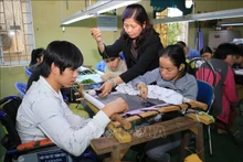 Học viên khuyết tật học nghề thêu tại Trung tâm Dạy nghề và đào tạo việc làm cho người khuyết tật tỉnh Thừa Thiên Huế (Ảnh minh hoạ: Hồ Cầu/TTXVN)