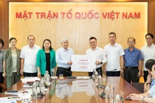 Tổng Biên tập Báo Nhân Dân Lê Quốc Minh trao số tiền quyên góp từ các cán bộ, phóng viên, nhân viên của Báo ủng hộ đồng bào khắc phục hậu quả bão, lũ. (Ảnh: SƠN TÙNG)