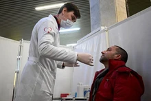 Nhân viên y tế lấy mẫu xét nghiệm Covid-19 cho người dân tại Moskva, Nga. (Ảnh: AFP/TTXVN)