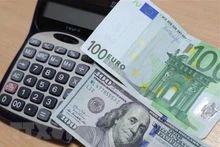 Đồng euro (phía trên) và đồng USD tại Brussels, Bỉ. (Ảnh: THX/TTXVN)