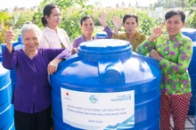 Phụ nữ Cà Mau nhận bồn chứa nước sinh hoạt trong khuôn khổ dự án “Nước là sự sống”. 