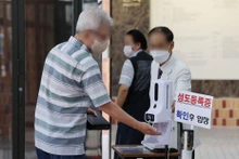 Kiểm tra thân nhiệt trước khi vào nhà thờ ở Seoul, Hàn Quốc, ngày 17/7/2022. (Ảnh: Yonhap)