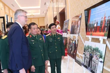Thượng tướng Hoàng Xuân Chiến, Thứ trưởng Quốc phòng và Phó Tổng Thư ký Liên hợp quốc Jean-Pierre Lacroix cùng các đại biểu xem triển lãm ảnh về phụ nữ với hoạt động gìn giữ hòa bình Liên hợp quốc.