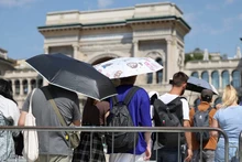 Người dân dùng ô để che nắng khi xếp hàng vào Nhà thờ Duomo trong đợt nắng nóng ở Milan, Italia, ngày 21/8/2023. (Ảnh: Reuters)
